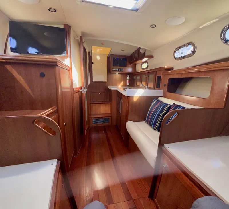 Slide: The Image of Interior of 2016 Marlow Pilot 31, featuring wood finishes and cozy seating. - 38