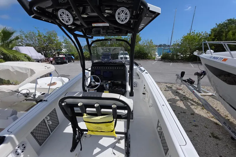 Slide: The Image of 2022 Wellcraft 222 Fisherman boat interior with steering console and seating, parked outdoors. - 15