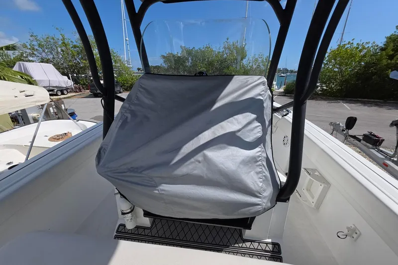 Slide: The Image of 2022 Wellcraft 222 Fisherman boat console covered, docked under clear blue sky. - 4