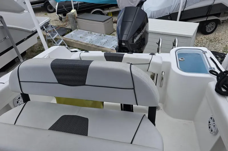 Slide: The Image of 2022 Wellcraft 222 Fisherman boat interior with seating and motor view. - 7