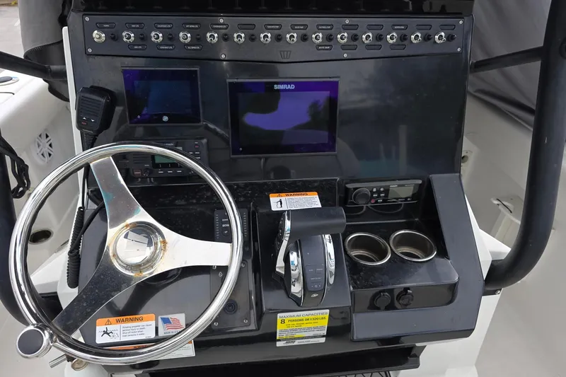 Slide: The Image of 2022 Wellcraft 222 Fisherman dashboard with steering wheel, controls, and navigation screens. - 8
