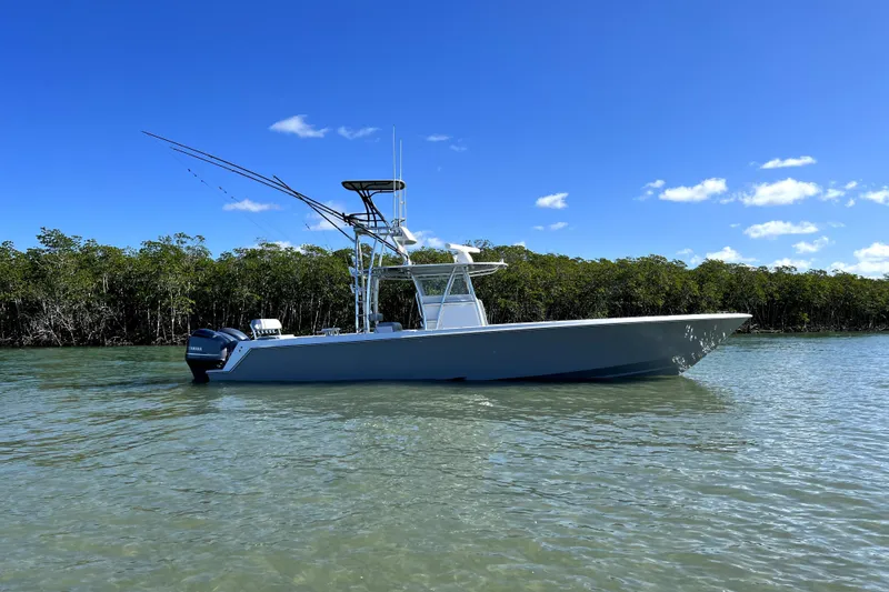 The Image of 2014 Contender 39 ST boat on calm water, clear blue sky, lush green mangroves. - 0