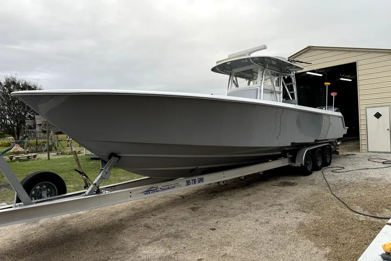 Slide: The Image of 2014 Contender 39 ST boat on trailer near a storage building. - 11