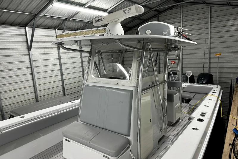 Slide: The Image of 2014 Contender 39 ST boat in a metal storage shed, featuring Garmin equipment. - 16