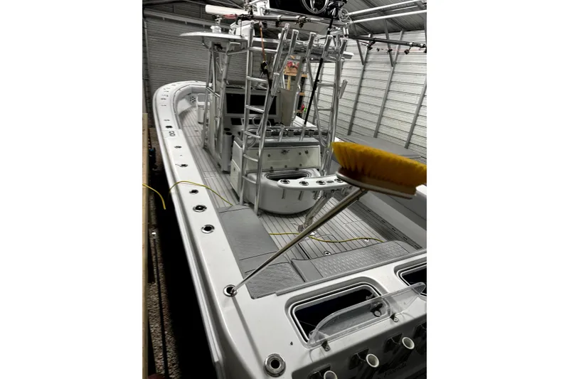 Slide: The Image of 2014 Contender 39 ST boat in storage, featuring a sleek design and fishing equipment. - 17