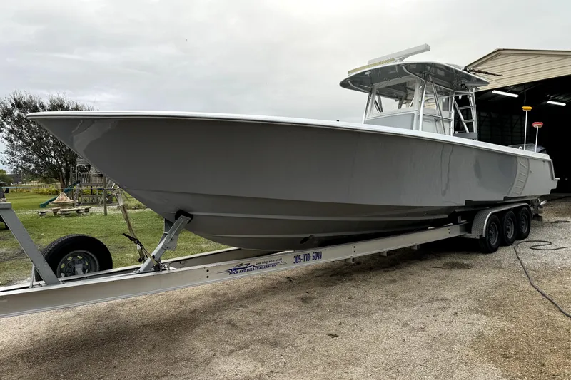 Slide: The Image of 2014 Contender 39 ST boat on trailer, parked outdoors near a shed. - 22