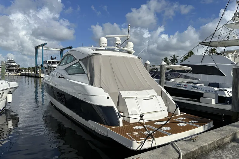 Slide: The Image of 2011 Cruisers Yachts 540 Sports Coupe docked at marina under blue sky. - 1