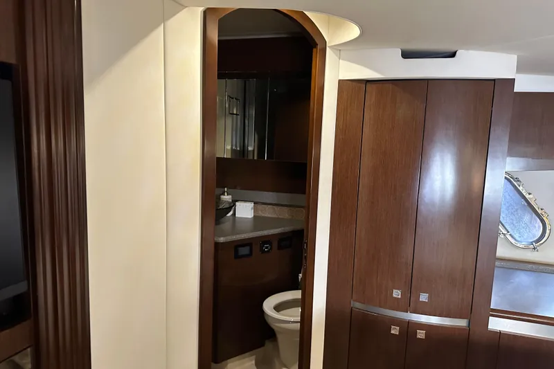 Slide: The Image of Interior of 2011 Cruisers Yachts 540 Sports Coupe, featuring elegant wood cabinetry and bathroom. - 29