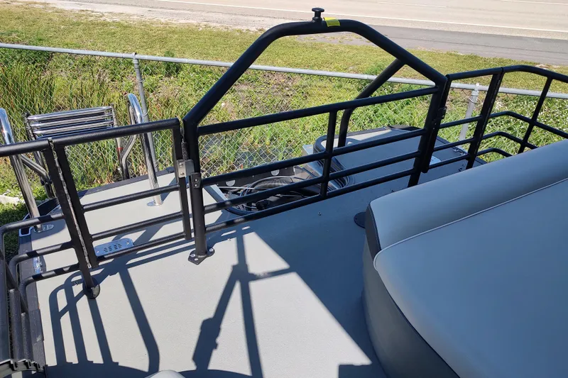 Slide: The Image of 2026 Sylvan MIRAGE X1 CLZ DH boat deck with railing and seating, near a fence. - 14