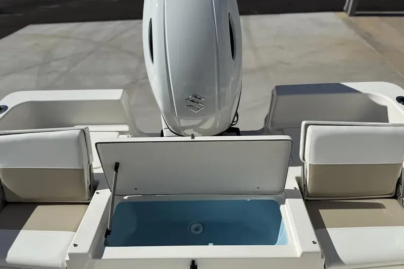 Slide: The Image of 2026 Bulls Bay 230 Center Console boat with open storage compartment and outboard motor. - 11