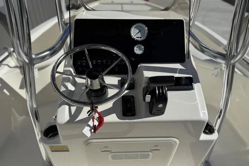 Slide: The Image of 2026 Bulls Bay 230 Center Console boat dashboard with steering wheel and controls. - 9
