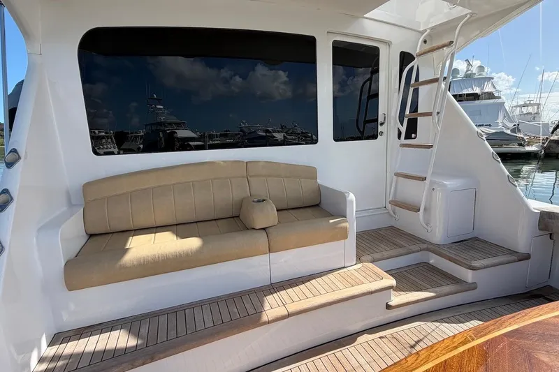 Slide: The Image of 2004 Viking 56 Convertible yacht with beige seating and wooden steps in a marina. - 14