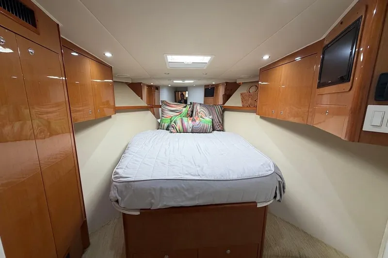 Slide: The Image of Luxurious cabin interior of 2004 Viking 56 Convertible yacht with cozy bed and wooden cabinetry. - 29