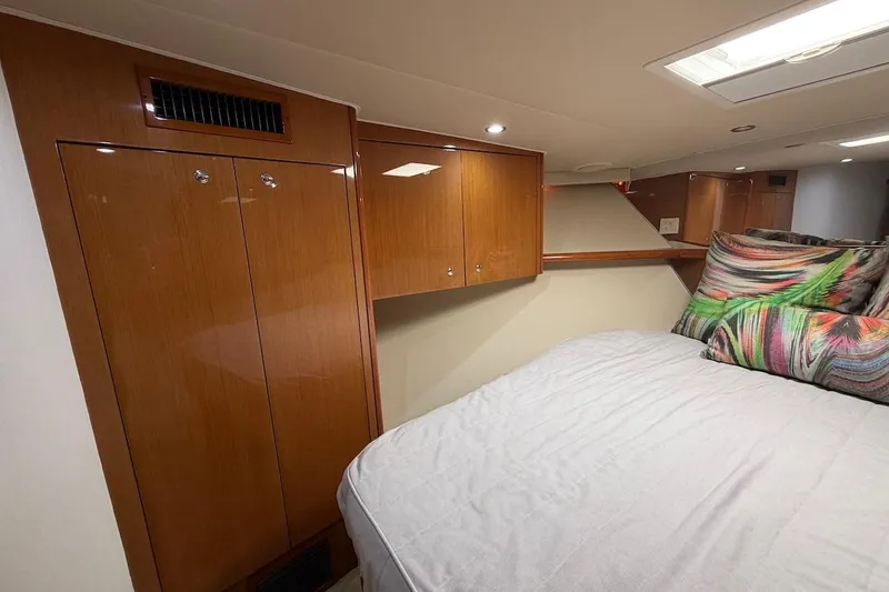 Slide: The Image of Luxurious cabin interior of 2004 Viking 56 Convertible yacht with wood cabinetry and colorful pillows. - 31