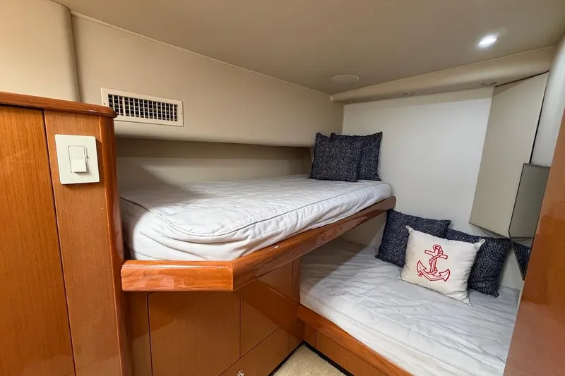 Slide: The Image of 2004 Viking 56 Convertible yacht cabin with bunk beds and nautical-themed pillows. - 33