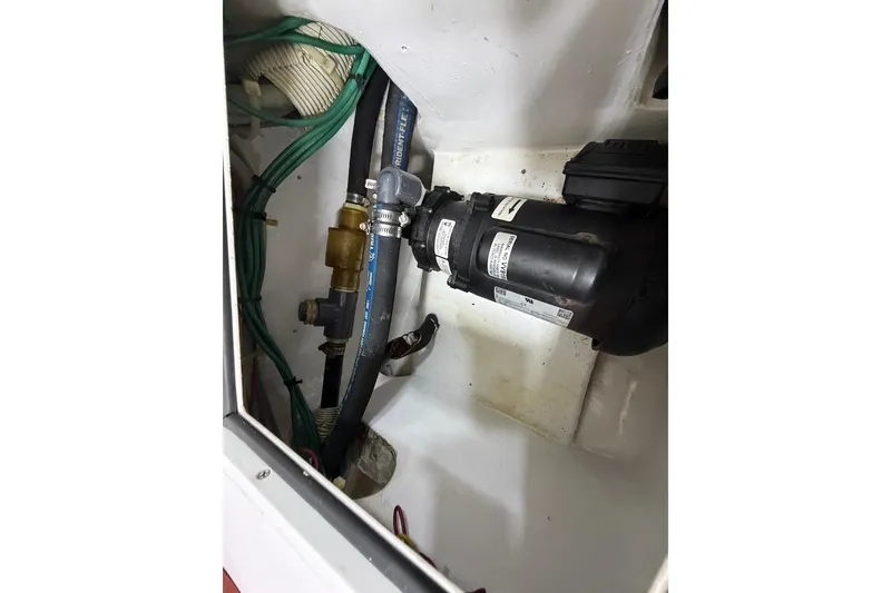 Slide: The Image of Engine compartment of 2004 Viking 56 Convertible with visible hoses and pump system. - 49