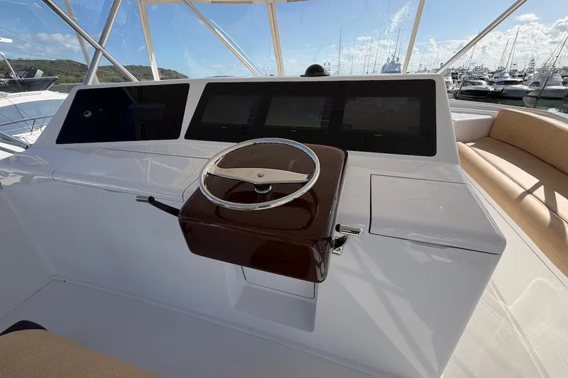 Slide: The Image of Helm of 2004 Viking 56 Convertible yacht with steering wheel and navigation screens. - 58