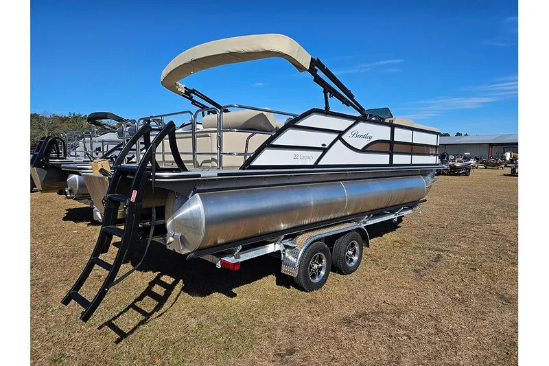 Slide: The Image of 2026 Bentley Pontoons Legacy 220 Swingback on trailer, displayed outdoors. - 3