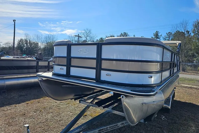 Slide: The Image of 2026 Bentley Pontoons Legacy 220 Swingback on trailer, parked outdoors under clear sky. - 5