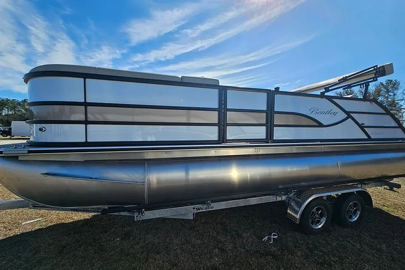 Slide: The Image of 2026 Bentley Pontoons Legacy 220 Swingback on trailer under blue sky. - 6