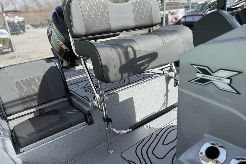 Slide: The Image of 2026 Xpress H20B Bay boat interior with gray seating and logo detail. - 12
