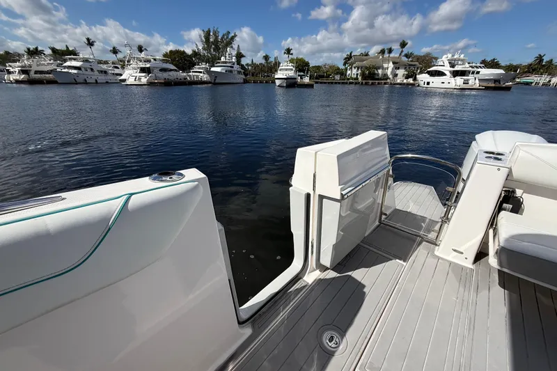 Slide: The Image of 2020 Regal 38 SAV boat deck with marina view, featuring luxurious seating and open water access. - 11