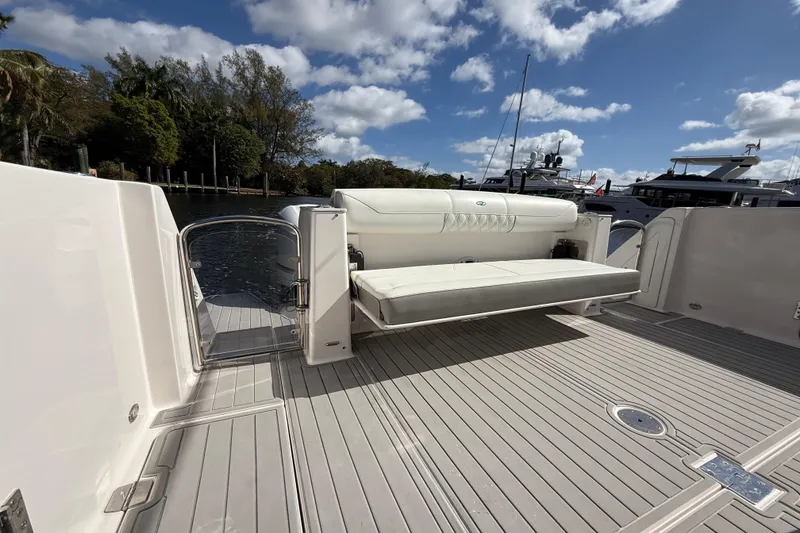 Slide: The Image of 2020 Regal 38 SAV boat deck with seating, docked under a blue sky. - 13