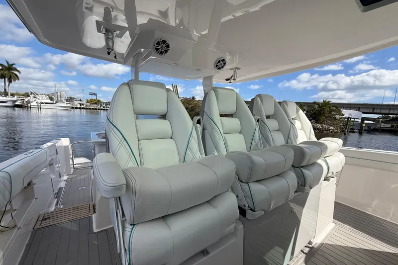 Slide: The Image of Luxurious seating on 2020 Regal 38 SAV boat, docked by a scenic waterfront. - 17