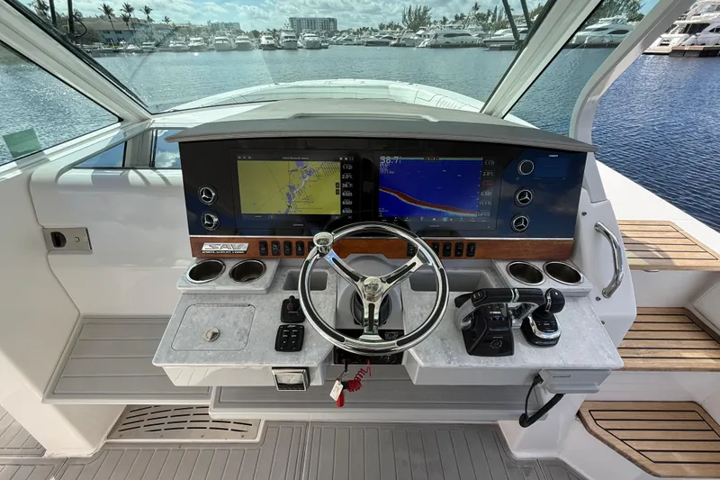 Slide: The Image of 2020 Regal 38 SAV helm with navigation screens and controls, docked at marina. - 18