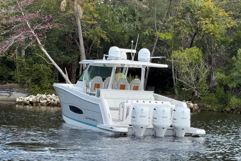 Slide: The Image of 2020 Regal 38 SAV boat with four engines on a serene waterway. - 6