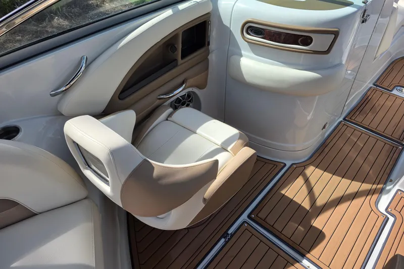 Slide: The Image of 2017 Crownline Eclipse E6 XS boat interior with beige seating and wood-style flooring. - 10