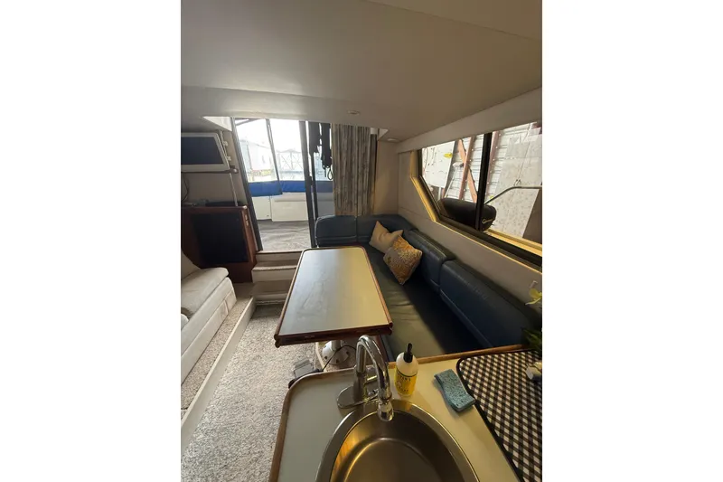 Slide: The Image of Interior of 1994 Carver 320 Voyager yacht with cozy seating and dining area. - 10