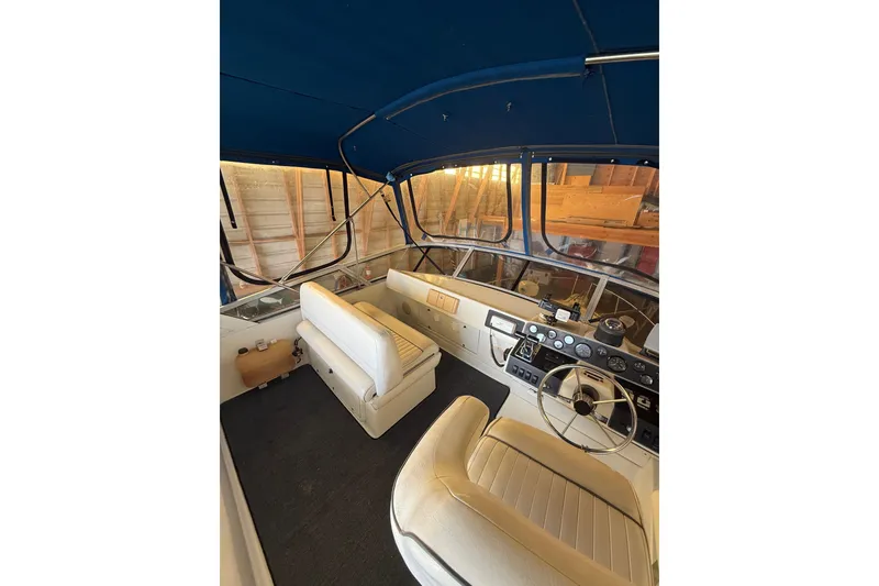 Slide: The Image of Interior of a 1994 Carver 320 Voyager boat with steering wheel and seating. - 23