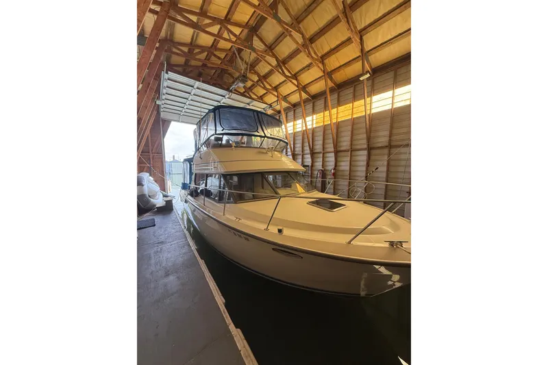 Slide: The Image of 1994 Carver 320 Voyager yacht docked in a wooden boathouse. - 3