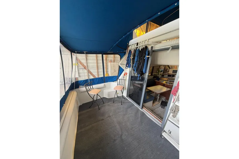 Slide: The Image of 1994 Carver 320 Voyager boat interior with seating, blue canopy, and nautical decor. - 5