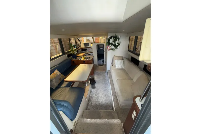 Slide: The Image of Interior of 1994 Carver 320 Voyager yacht with cozy seating and dining area. - 7