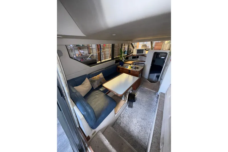 Slide: The Image of Interior of 1994 Carver 320 Voyager yacht with cozy seating and dining area. - 8