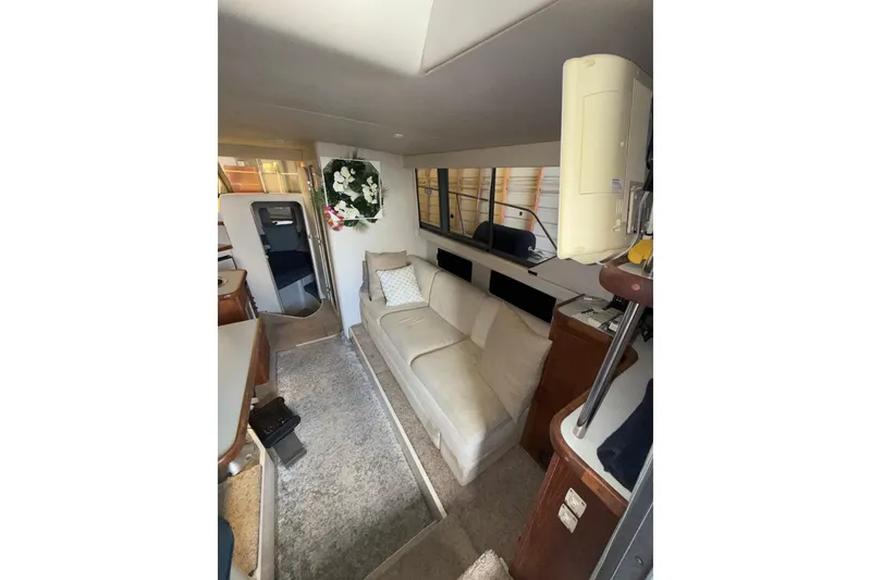 Slide: The Image of Interior of 1994 Carver 320 Voyager yacht with beige sofa and floral decor. - 9