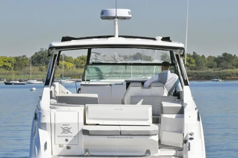 Slide: The Image of 2022 Sea Ray Sundancer 320 yacht on calm water, rear view with seated person. - 4