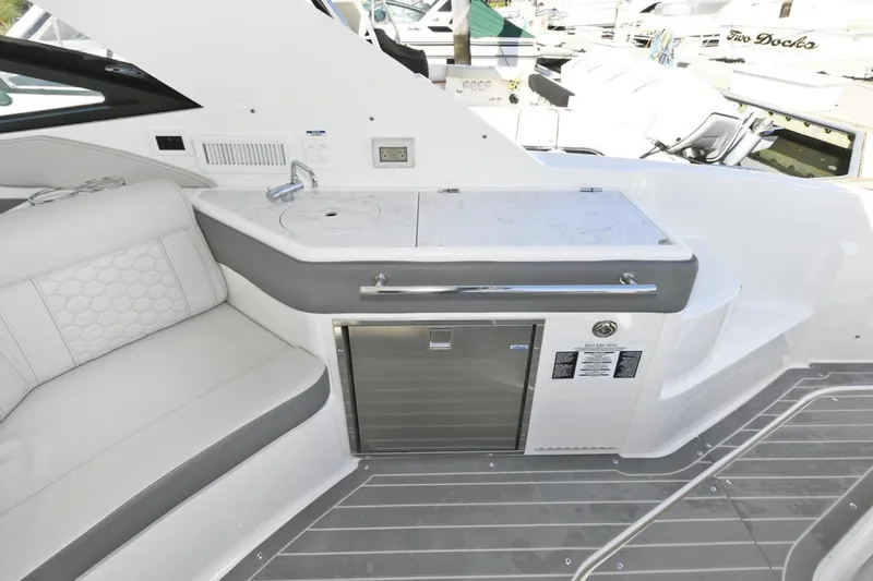 Slide: The Image of 2022 Sea Ray Sundancer 320 yacht interior with kitchenette and seating area. - 8