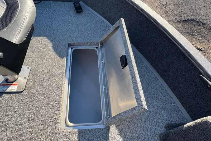 Slide: The Image of 2023 Lowe Fishing Machine 1675SC boat with open storage compartment and seat. - 13