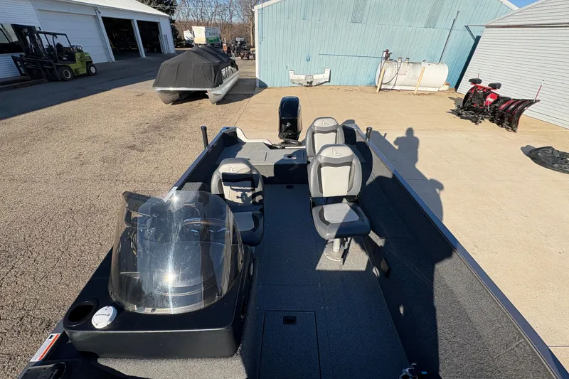 Slide: The Image of 2023 Lowe Fishing Machine 1675SC boat with seating, parked outdoors. - 14