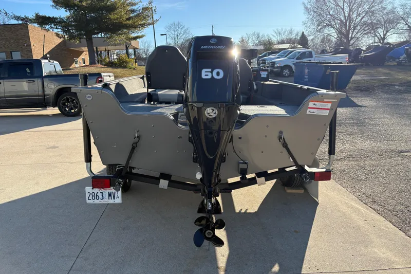 Slide: The Image of 2023 Lowe Fishing Machine 1675SC with Mercury 60 engine, parked outdoors. - 2