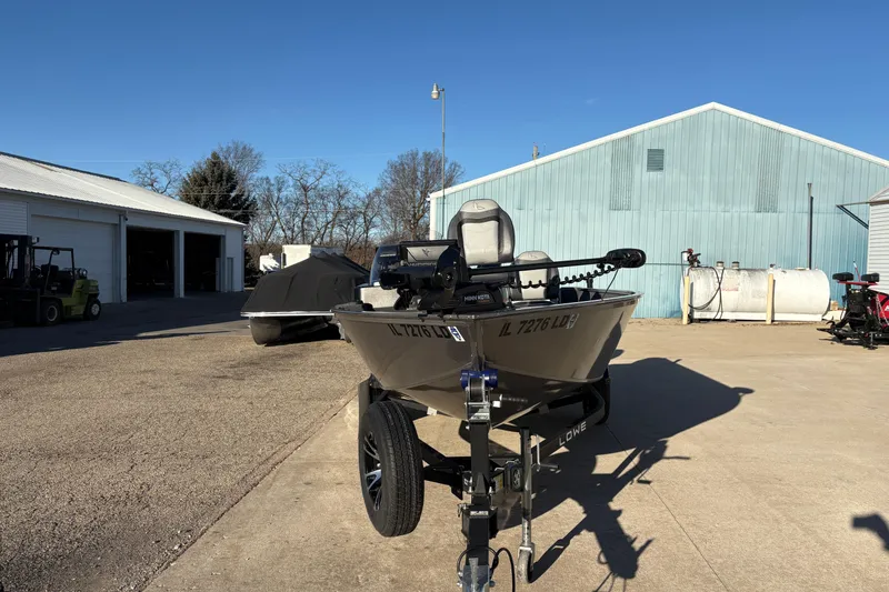 Slide: The Image of 2023 Lowe Fishing Machine 1675SC boat parked outdoors on a sunny day. - 6