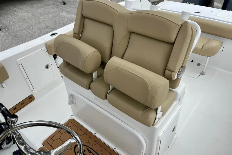 Slide: The Image of 2018 Sea Hunt Gamefish 27 Coffin Box boat with tan cushioned seating and steering wheel. - 15