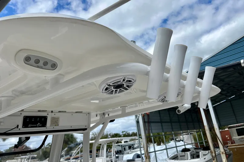 Slide: The Image of 2018 Sea Hunt Gamefish 27 Coffin Box boat with rod holders and speakers under a cloudy sky. - 19