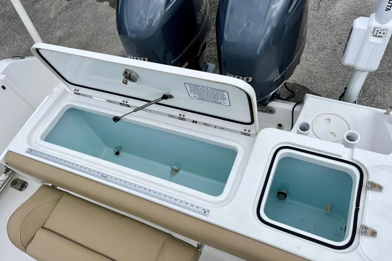 Slide: The Image of 2018 Sea Hunt Gamefish 27 Coffin Box with open storage compartments and dual outboard motors. - 33