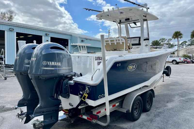 Slide: The Image of 2018 Sea Hunt Gamefish 27 Coffin Box boat with dual Yamaha engines on trailer. - 4