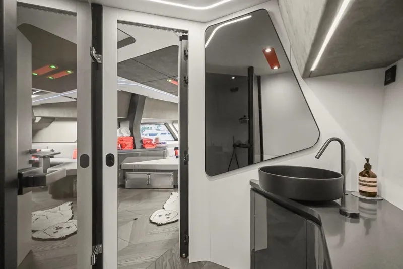 Slide: The Image of Modern yacht interior with sleek bathroom design, featuring a black sink and geometric mirror. Maori 64, 2025. - 19