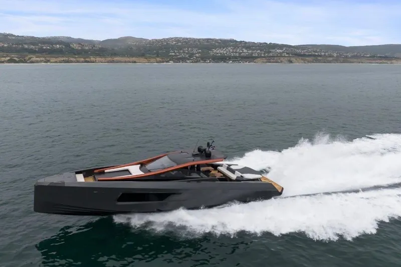 Slide: The Image of Sleek 2025 Maori 64 yacht cruising near rocky coastline. - 5
